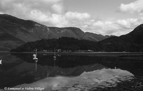 Loch Leven is like a mirror on a quiet day, the village of Glencoe lies in the background